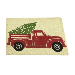 Een deurmat met een rode oude vrachtwagen en een groene kerstboom op een lichte achtergrond.