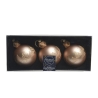 Drie bronzen kerstballen met geometrische patronen in een elegante verpakking.