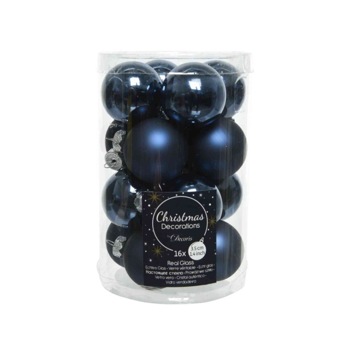Een transparante doos met donkerblauwe kerstballen van verschillende maten en glanzende afwerkingen.