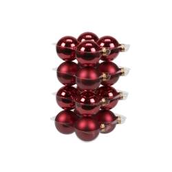 Shiny red Christmas ornaments stacked neatly in clear plastic packaging.