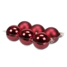 Six shiny, deep red Christmas ornaments resting in a clear plastic holder.