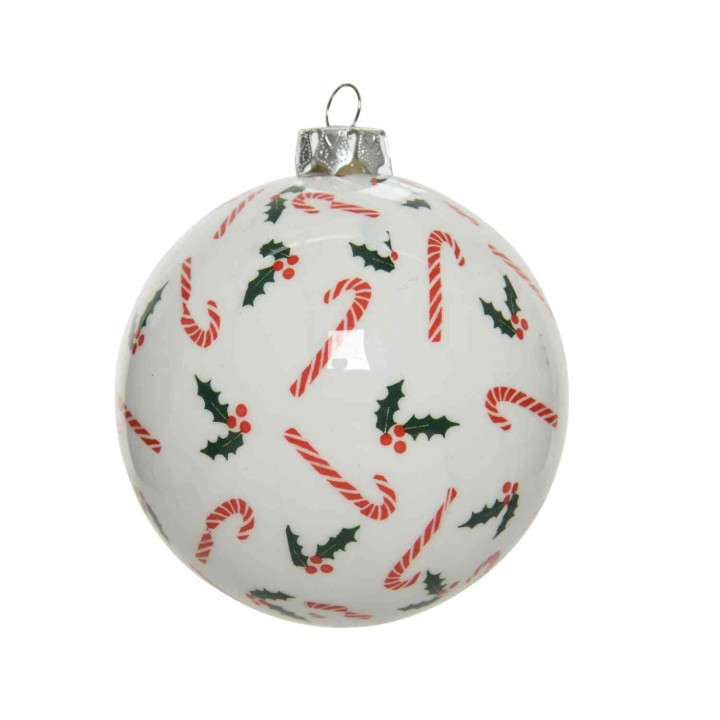 Witte kerstbal met rode zuurstokken en groene hulstbladeren in een speelse patroon.