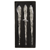 Three delicate, clear glass icicles with textured surfaces, elegantly displayed on a black backgr...