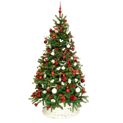 A festive green Christmas tree adorned with red and white ornaments in a woven basket.
