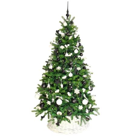 A lush green Christmas tree adorned with black and white ornaments, resting in a woven basket.