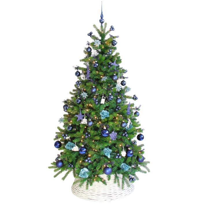 Groene kerstboom versierd met blauwe en teal ornamenten en lichtjes, in een witte mand.