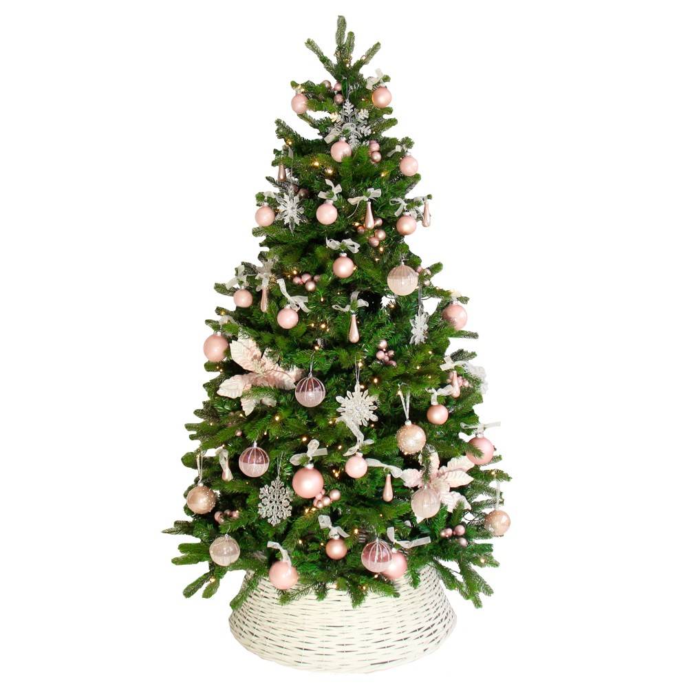 Een groene kerstboom versierd met roze ballen, sneeuwvlokken en een witte mand als standaard.