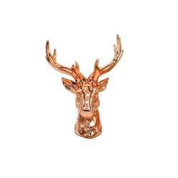 A glossy, rose gold deer bust with intricate antlers, showcasing modern decor style.