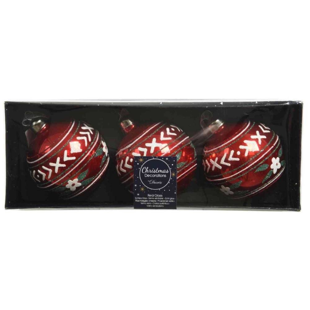 Three shiny red Christmas ornaments with intricate white and green designs in a black box.