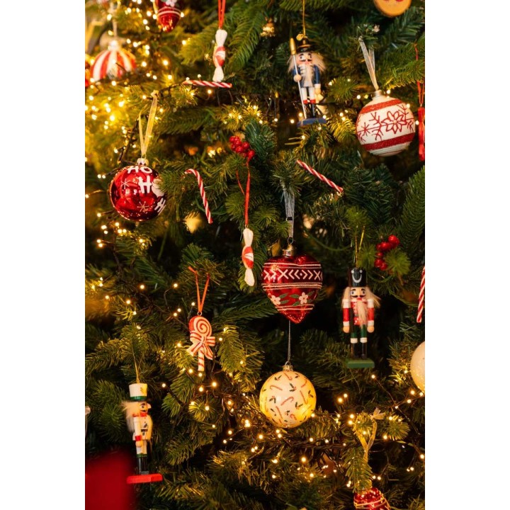 Feestelijke kerstboom met kleurrijke versieringen, lichtjes en houten figuren.