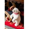 A fluffy white polar bear figurine stands proudly on a festive red rug, surrounded by decorative ...