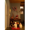 A cozy entryway with festive decor, featuring plush snowmen, candles, and a small tree.