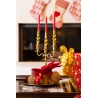 A festive centerpiece with gold candle holders, red candles, and decorative ornaments.