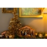 A festive scene with a golden tree, nativity set, and ornaments against a warm backdrop.