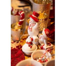 A festive table adorned with cheerful snowman figurines and red and white decorations.