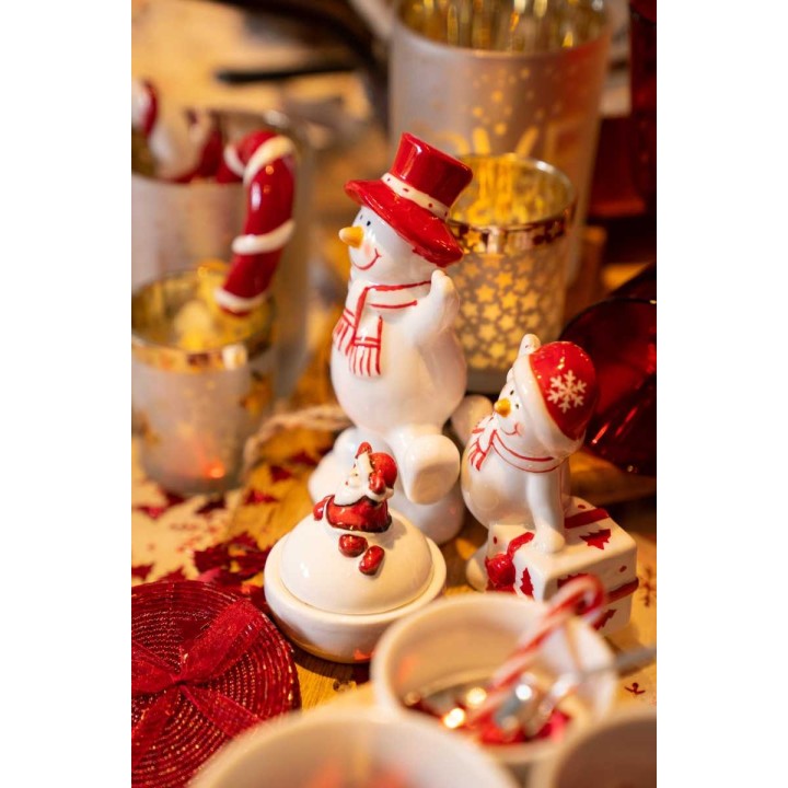 Witte sneeuwpoppen met rode accessoires, omgeven door feestelijke decoraties en glinsterende deta...