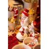 A festive table adorned with cheerful snowman figurines and red and white decorations.