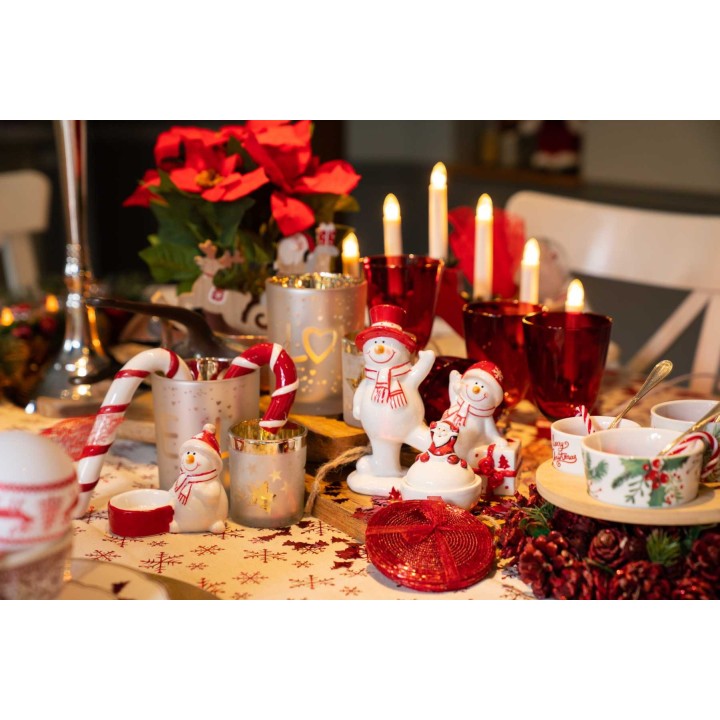 Feestelijke tafel met sneeuwpoppen, rode glazen, kaarsen en kerstversiering.