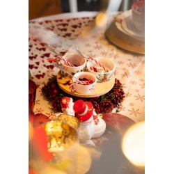 Gezellig gedekte tafel met kerstdecoraties, kommetjes en een sneeuwpop in warme tinten.