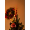 A festive Christmas tree adorned with red ornaments and a golden star topper, set against a wreath.
