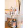 Two silver nutcracker figurines stand beside elegant candles on a warm wooden surface.