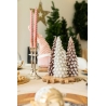 Elegant table setting with pastel-hued tree candles, silver accents, and festive decor.