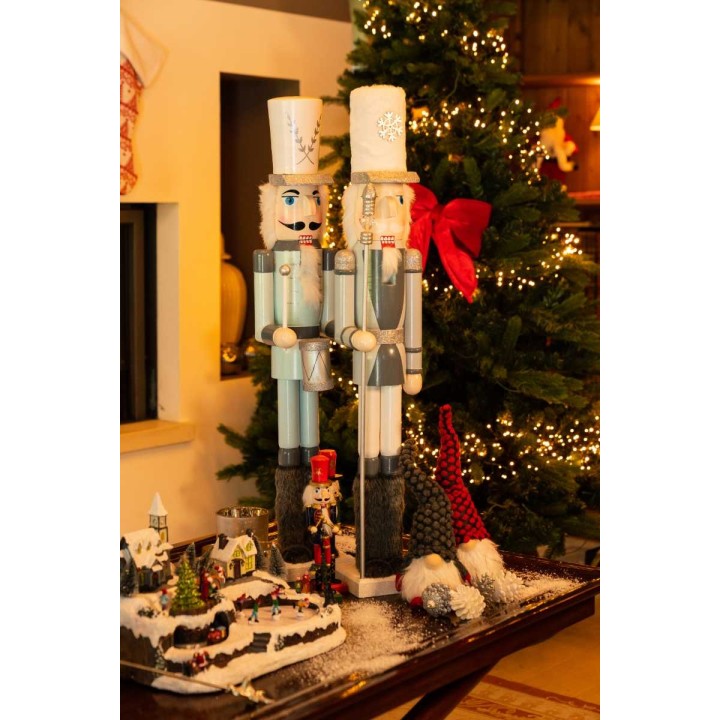 Twee kleurrijke notenkrakers staan naast een versierde kerstboom, omringd door feestelijke decora...