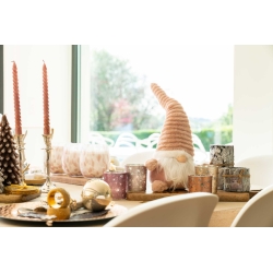Een sfeervolle tafel met kerstdecoraties, kaarsen, een schattige gnome en glinsterende ornamenten.