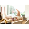 Een sfeervolle tafel met kerstdecoraties, kaarsen, een schattige gnome en glinsterende ornamenten.