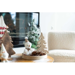 Sfeervolle kerstdecoratie met houten bomen, een sneeuwpop en dennenappels op een tafel.