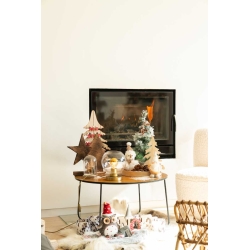 Houten tafel met kerstdecoraties, een open haard en een cozy sfeer.