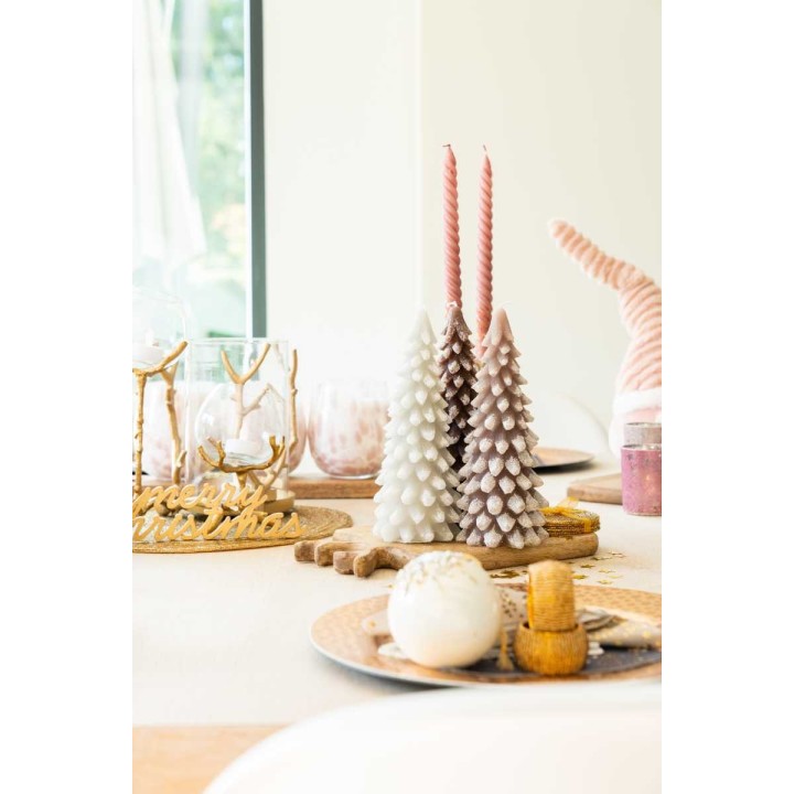 Sfeervolle tafel met pastelgekleurde kaarsen, kerstbomen en decoratieve schalen.