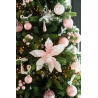 A festive tree adorned with pink ornaments, ribbons, and a large pink poinsettia.