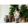 A whimsical gnome stands beside festive trees and decorative candle holders.