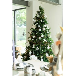 Een groene kerstboom versierd met witte en zilveren ballen, bloemen en glinsterende details.