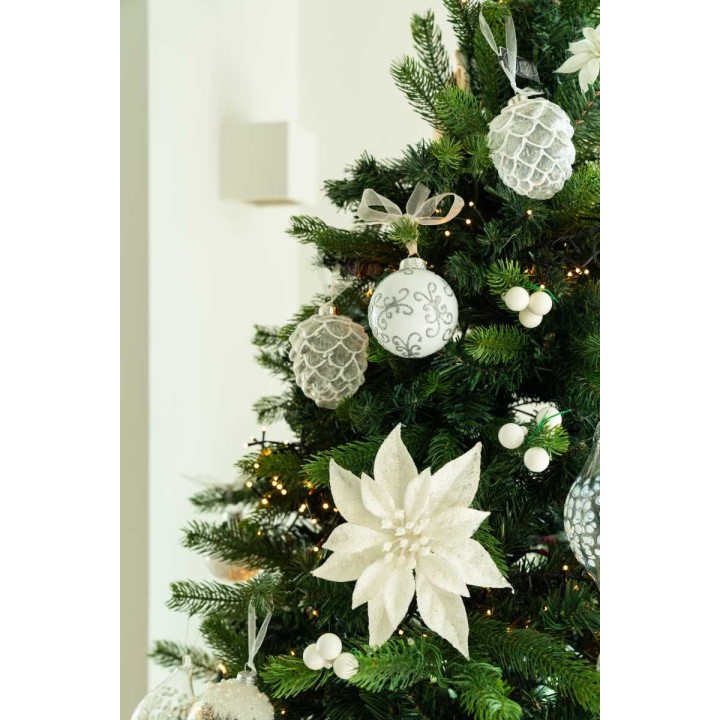 Witte en zilveren kerstballen en een bloem hangen elegant aan een groene dennenboom.