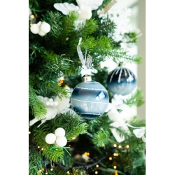 A festive tree adorned with blue and white ornaments, white berries, and twinkling lights.