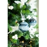 A festive tree adorned with blue and white ornaments, white berries, and twinkling lights.