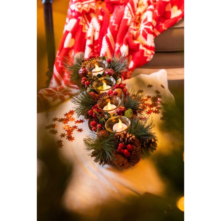 Stijlvolle kerstdecoratie met kaarsen, dennenappels en een warme, rode plaid.