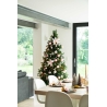 A beautifully decorated Christmas tree with pink ornaments stands beside a cozy dining area.