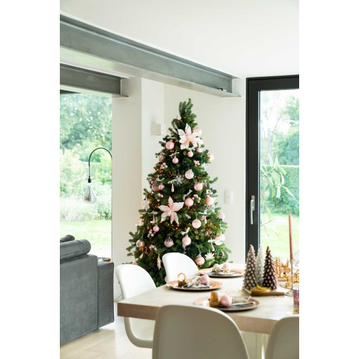 Elegante kerstboom met roze versieringen, een moderne woonkamer en een gezellige eettafel.