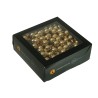 A square black box with a transparent lid, filled with shiny golden decorative balls.