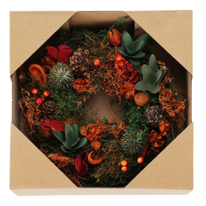 Kerstkrans in een doos, versierd met groen, dennenappels en kleurrijke herfstbloemen.