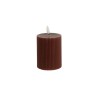 A cylindrical, ribbed brown candle with a small white wick on top.