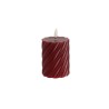 A deep red candle with a twisted texture and a small white wick on top.