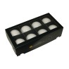 A sleek black box containing nine smooth, white spherical objects arranged neatly.