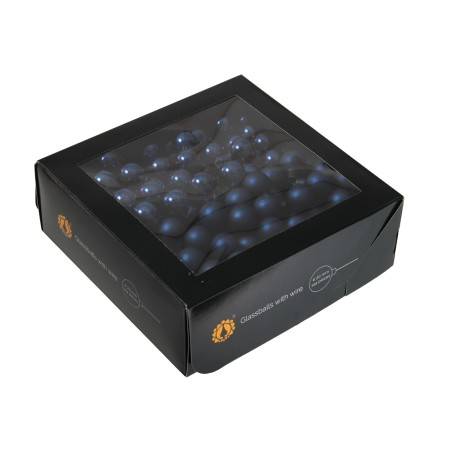 A black box with a clear lid, filled with round dark blue candies. A black box with a clear lid, filled with round dark blue candies.