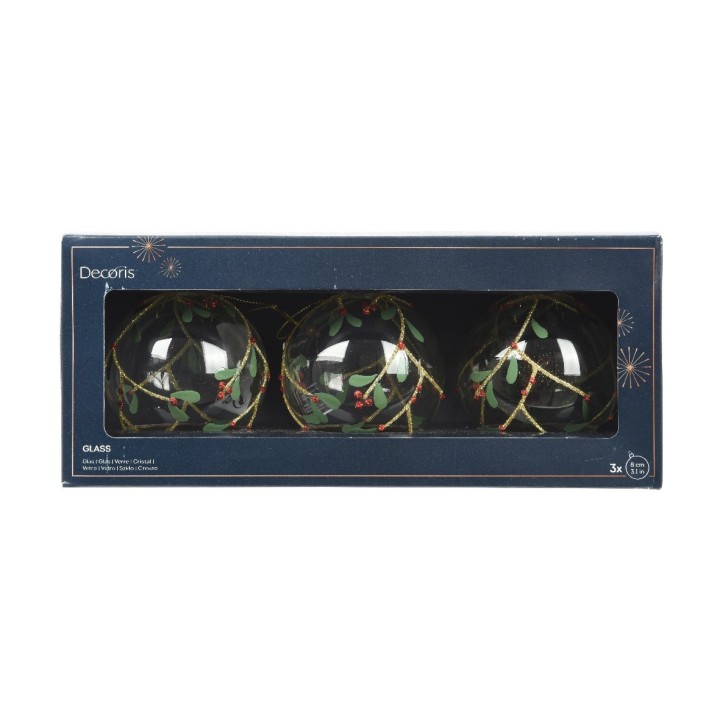 Drie glazen kerstballen met groene takken en rode bessen in een elegante doos.
