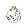 Transparante kerstbal versierd met groene takjes en rode bessen, afgewerkt met gouden details.