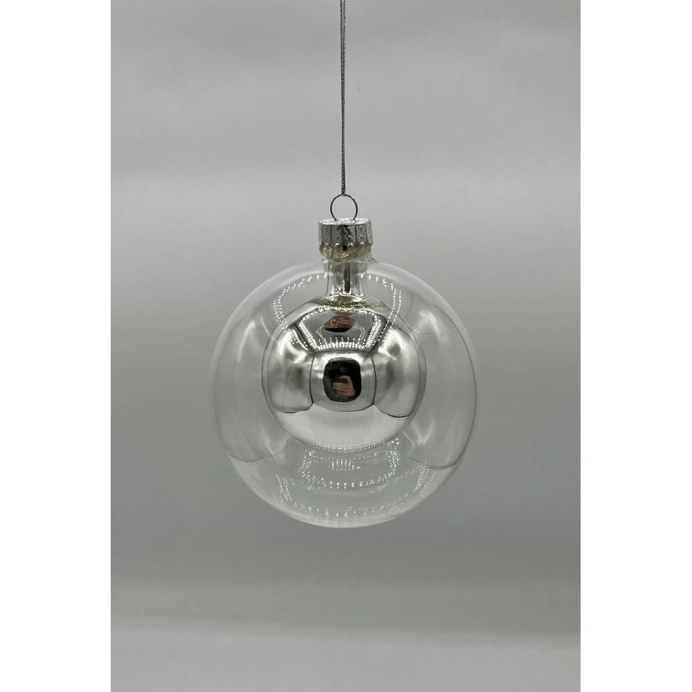 A shiny, silver Christmas ornament with a spherical glass design, suspended by a thin string.